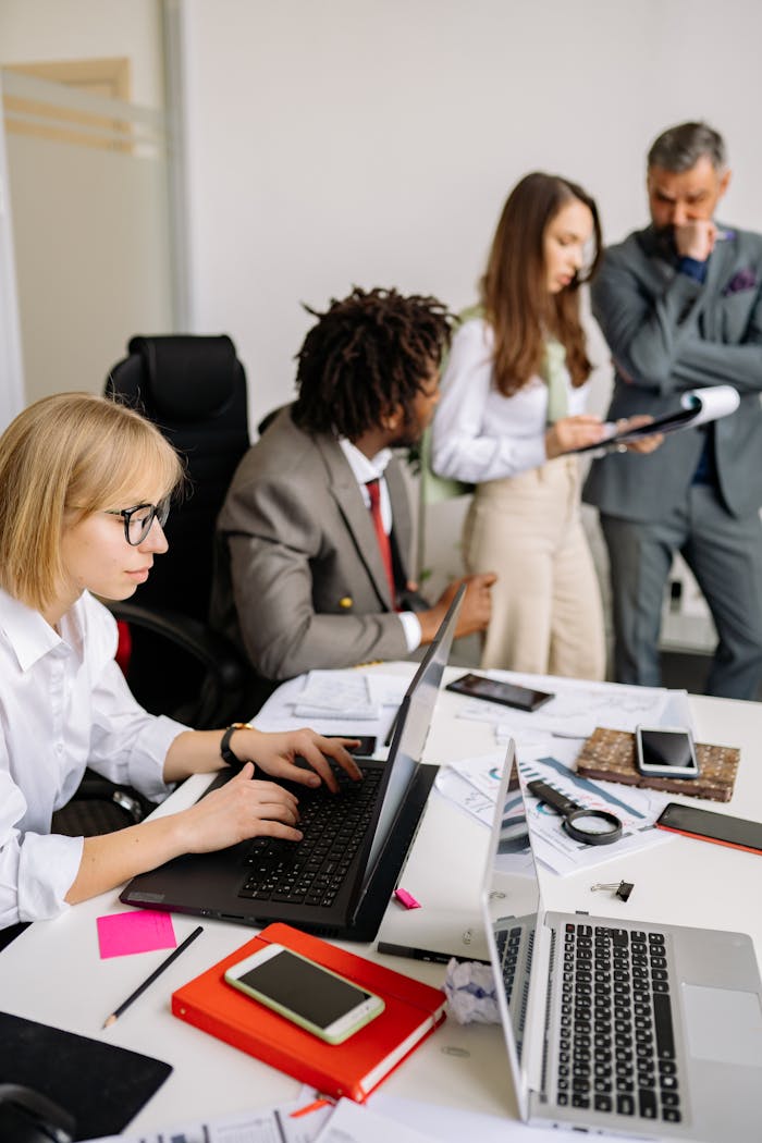 heros-img Business professionals engaged in teamwork and discussion in a modern office setting.